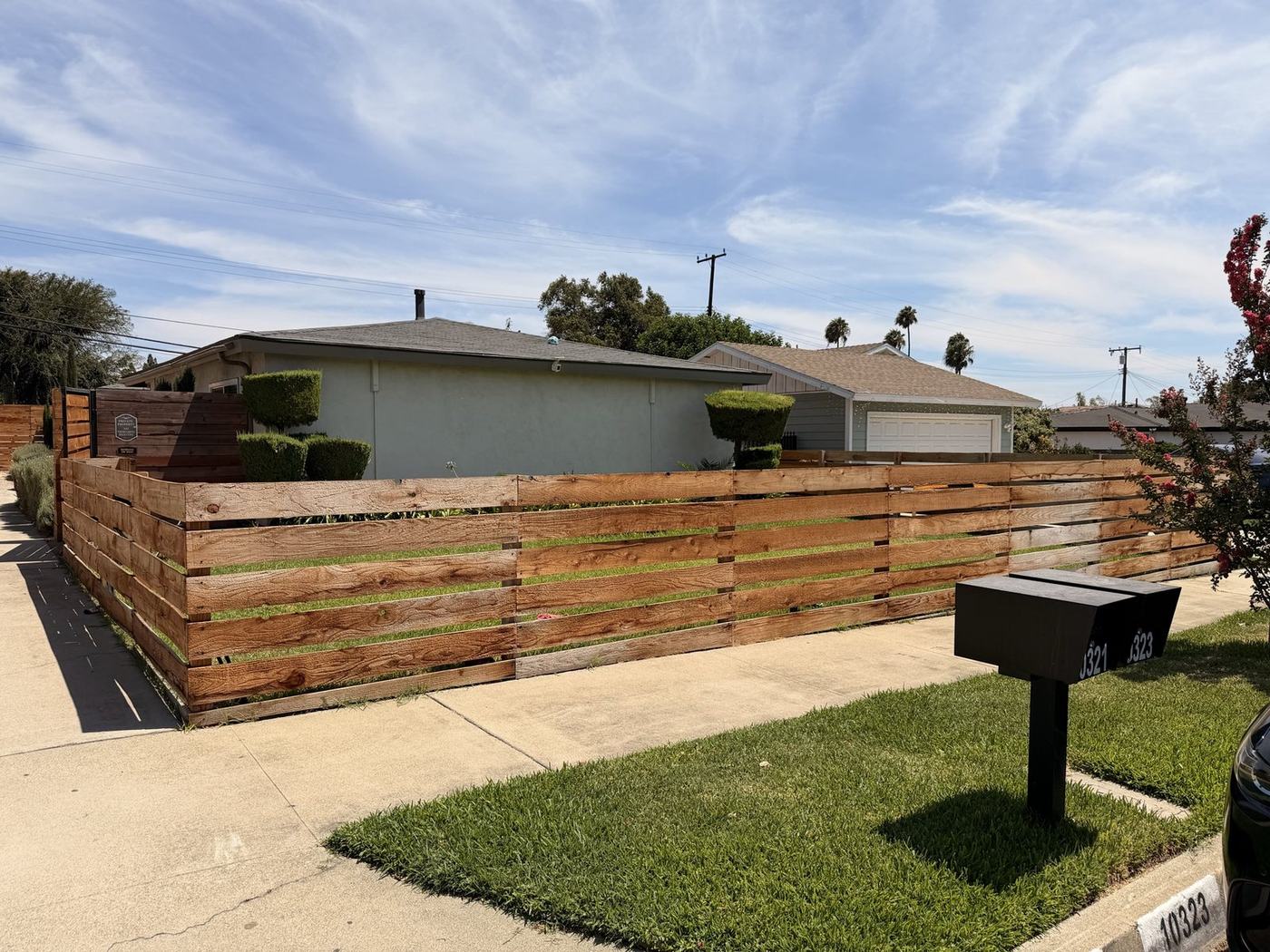 Single-story home exterior with horizontal wood fence and lawn at Her Aria recovery residence, Montclair CA