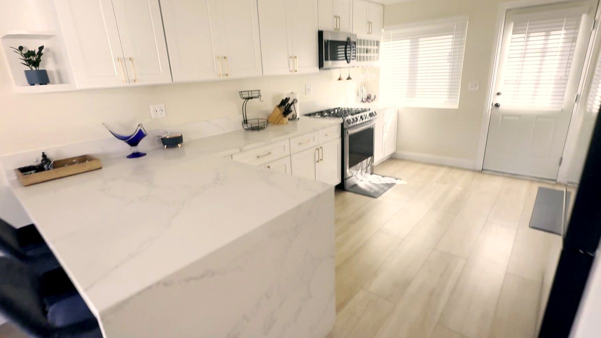 Kitchen in a women's recovery residence in Montclair, CA — white shaker cabinetry, quartz counters, stainless appliances